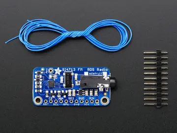 Si4713 FM transmitter module top photo with antenna wire and loose 11 pin header for soldering reference.